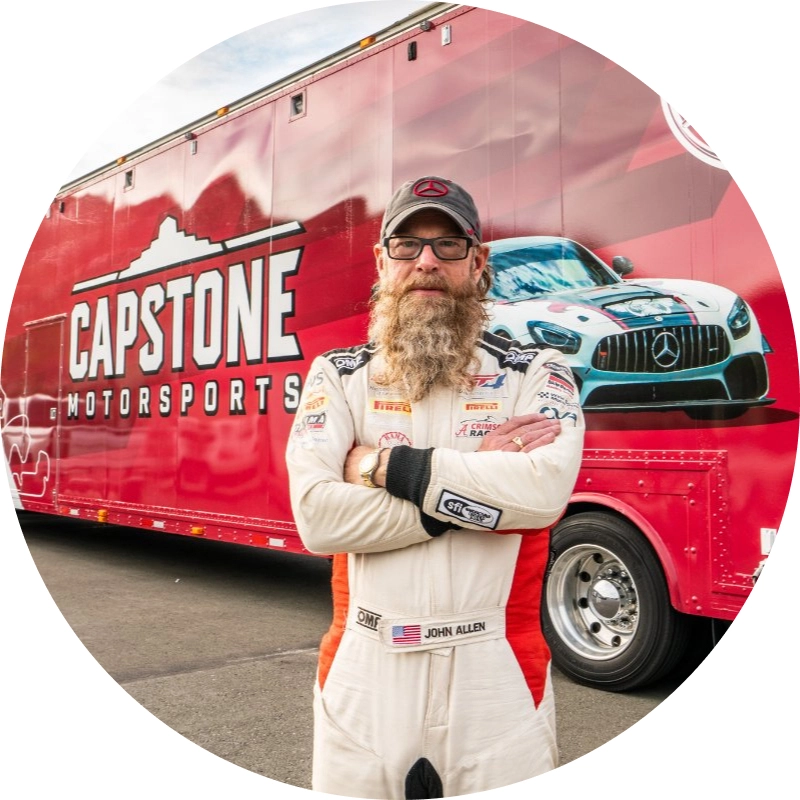 Jon standing in front of wrapped racing trailer